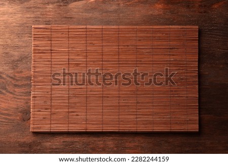 Bamboo mat on wooden table, top view. Space for text Royalty-Free Stock Photo #2282244159