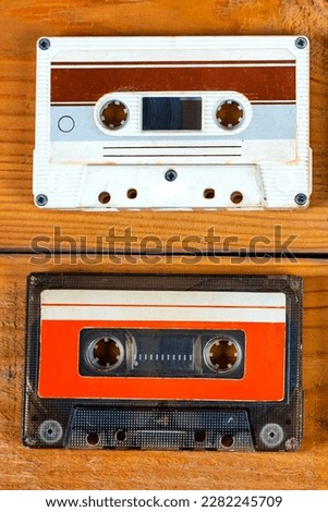 Pair of Old Audio Cassettes on a Wooden Planks Background closeup