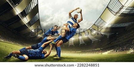 Professional sport. Men, rugby players during game, catching ball at 3D open air stadium. Blurred audience on background. Emotions. Concept of match, sport, competition, action and motion, game, cup. Royalty-Free Stock Photo #2282248851