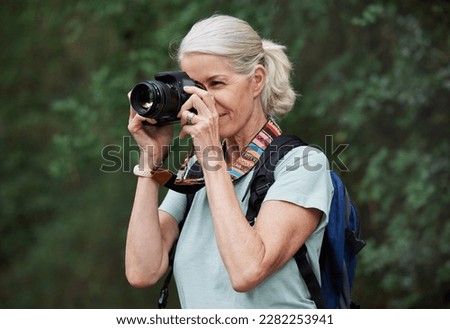 Woman, hiking and photography with camera in nature, outdoor or green environment. Female hiker, tourist and travel photographer on trekking adventure, sightseeing journey or explore scenery in woods