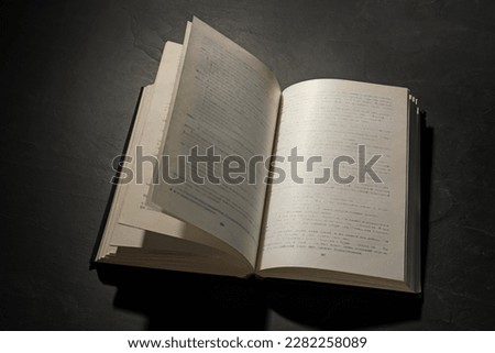 Open hardcover book on black textured table