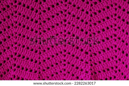 Magenta crochet texture with chevron stitch. Crochet fabric with zigzag pattern.