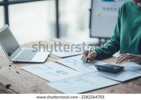 Financial Businesswomen analyze the graph of the company's performance to create profits and growth, Market research reports and income statistics, Financial and Accounting concept.