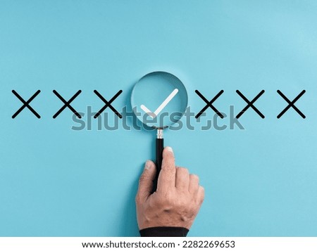 Focusing on the right choice concept. Hand holds magnifying glass focusing on the checkmark or tick right symbol next to wrong cross icons. Royalty-Free Stock Photo #2282269653
