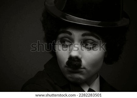black and white portrait of a girl in the image of an English silent movie comedian on a black background