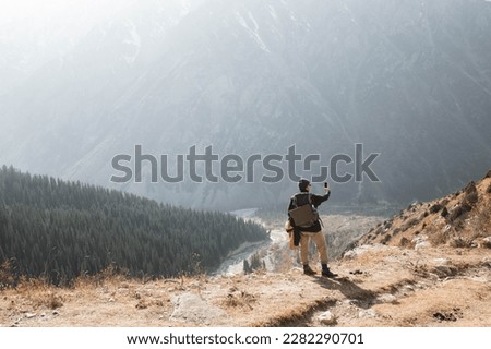 man taking a selfie in front of the mountains