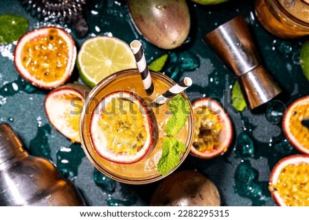 Sweet colorful tropical cocktail with passion fruit, lime and mint. Long boozy alcohol passion fruit drink over dark background copy space Royalty-Free Stock Photo #2282295315
