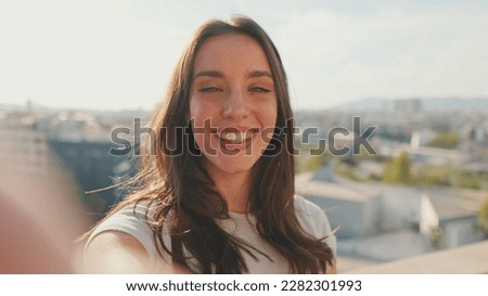 Close-up of young woman taking selfie hand peace sign while standing on balcony