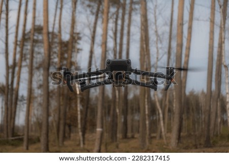Photo of drone in forest: A stunning close-up of a futuristic drone amidst lush green foliage. Perfect for nature and tech projects. Download now to enhance visuals.