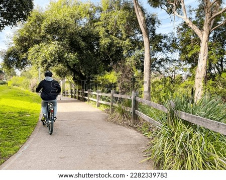 Male model riding bike in a park in Parramatta, Sydney, Australia. Royalty-Free Stock Photo #2282339783