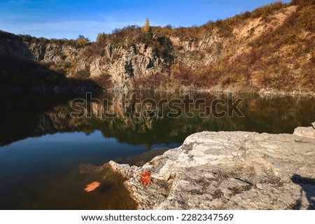 Natural conceptual autumn idea. Quarry landscape with leaves in fall colors. Photo taken in Kielce, Poland. 