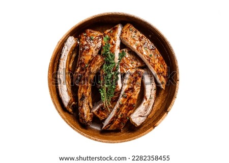 Cut BBQ grilled pork rack spareribs in a wooden plate. Isolated on white background Royalty-Free Stock Photo #2282358455