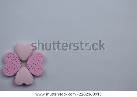 Love and romance, Small hearts in pink, placed on the edge of a white background, photographed from above, showing love and romance.  spotted, flower, shaped