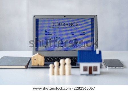 Wooden stock and house on white background laptop, property insurance concept