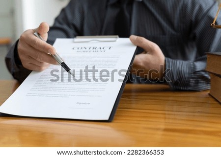 Lawyer working in a law office reading agreement contract documents and signing, Sign the auction documents.