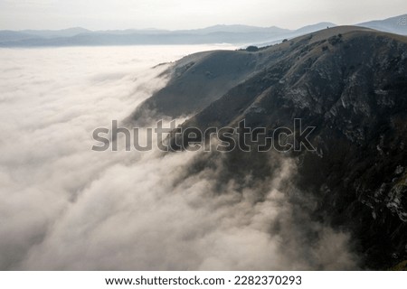 stunning cloud inversion over mountain morning view drone arial perspective above top down misty clinging to side  valley obscured amazing unique weather phenomena dew point