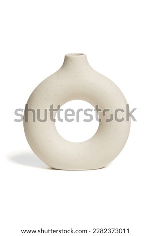 Close-up shot of a beige ceramic scandinavian vase. An empty donut vase is isolated on a white background. Home decor element. Front view. Royalty-Free Stock Photo #2282373011