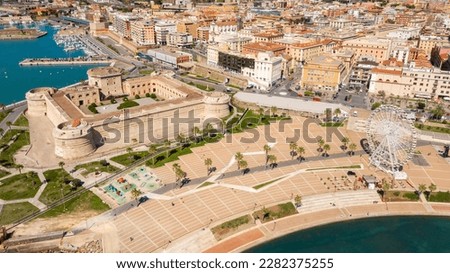 Aerial view of Fort Michelangelo, located in the port of Civitavecchia, in the Metropolitan City of Rome, Italy. On the city's waterfront is a park and a large white Ferris wheel. Royalty-Free Stock Photo #2282375255