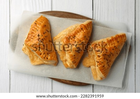 Fresh delicious puff pastry on white wooden table, top view Royalty-Free Stock Photo #2282391959