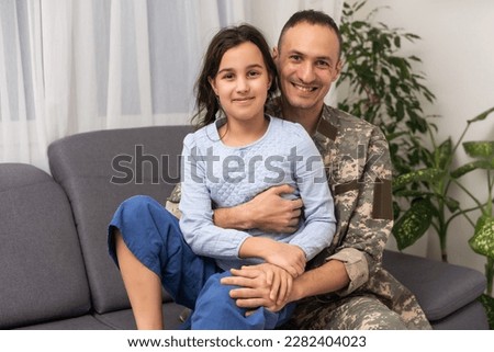military father hugging his daughter.