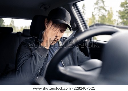 Tired man in car. Sleepy drowsy driver, fatigue. Driving and sleeping in vehicle. Exhausted, bored or drunk person. Serious upset man with stress, despair, anxiety or melancholy. Problem in traffic. Royalty-Free Stock Photo #2282407521