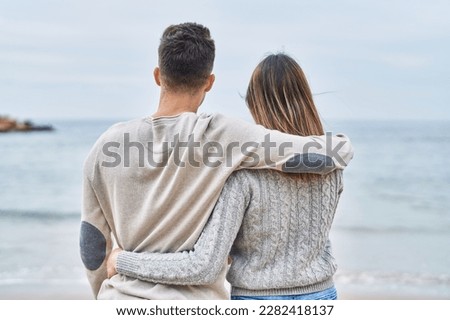 Man and woman couple hugging each other on back view at seaside Royalty-Free Stock Photo #2282418137