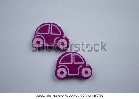 Purple cars.  Wooden purple cars placed on a white background, photographed from above.