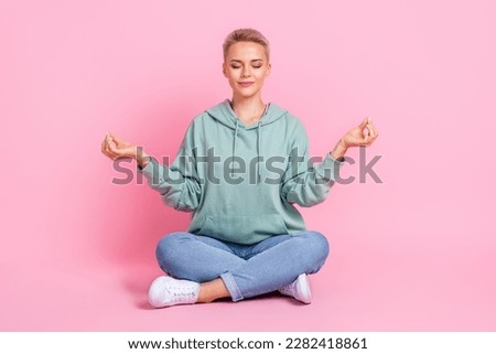 Full length photo of adorable lady wear trendy clothes sitting empty space practicing yoga isolated on pink color background