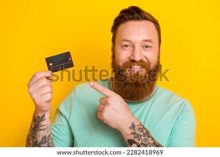 Photo of attractive rich successful man wear stylish clothes hold plastic card demonstrates nfc isolated on yellow color background