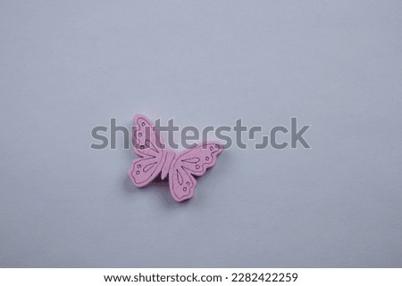 little butterfly.  Wooden pink small butterfly placed on a white background, photographed from above.  freedom fly