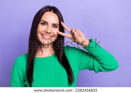 Photo of adorable funny woman wear green pullover showing v-sing cover eye isolated purple color background