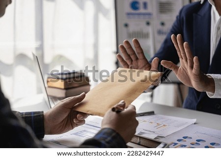 Young businessman being offered money but refusing to accept bribes Showing no corruption and bribery businessman refuse money offered by his partner - anti bribery and corruption concept Royalty-Free Stock Photo #2282429447