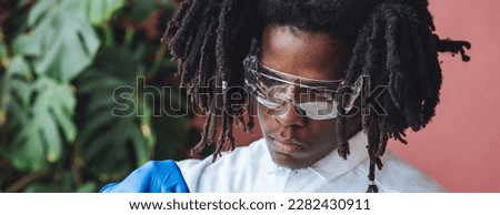 Male African American scientist working in the laboratory making biological test, scientific research. Concept of multiethnic multiracial people in science, professional biologist. Banner