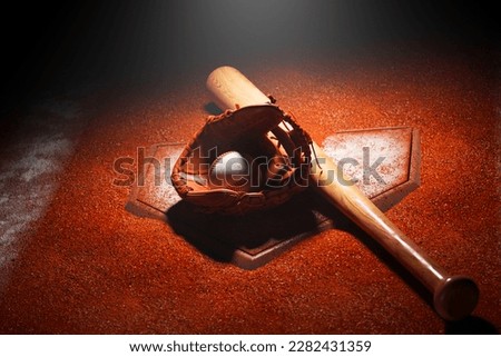 Baseball equipment on a dark stadium with orange gravel dirt
