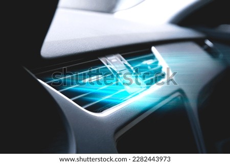 Cold from the car air conditioner. Air vents with streams of blue air flow. Air purification and filtration. Clean fresh smell. Vehicle odor removal. Royalty-Free Stock Photo #2282443973