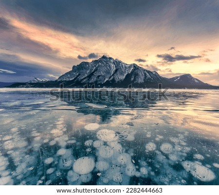 beautiful view of Frozen Abraham Lake with rocky mountains and natural bubbles frost in the morning on winter at Banff national park, Alberta, Canada
