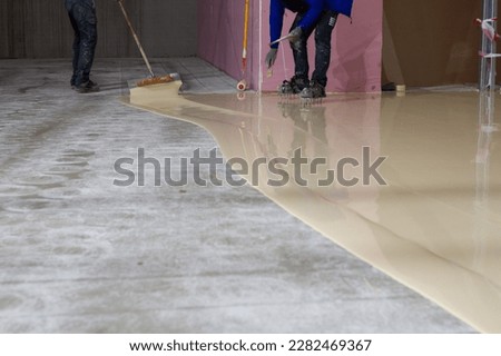 The worker who applied the resistant epoxy resin in the new hall was highly skilled and experienced in the application of epoxy coatings.  Royalty-Free Stock Photo #2282469367