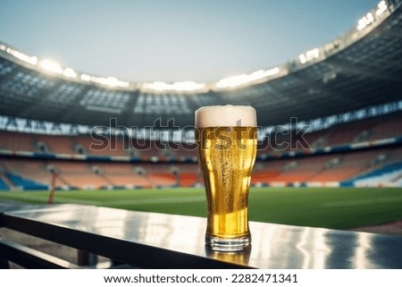 Glass of beer on football stadium background Royalty-Free Stock Photo #2282471341