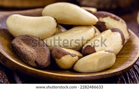wooden spoon with many unshelled Amazon nuts, also called acre nut, Bolivian walnut, Brazil nut, macro photo, closeup. Acre chestnut in wooden spoon, typical of the Amazon rainforest
