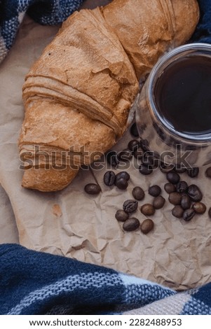 Coffee beans, chocolate and croissant on paper background