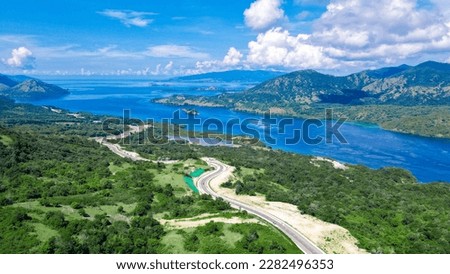Aerial view of green meadows, hills and the road. Top view from drone of rural road mountains. Beautiful landscape with roadway, green grass, sky with clouds in Golo Mori, Labuan Bajo Flores Indonesia Royalty-Free Stock Photo #2282496353