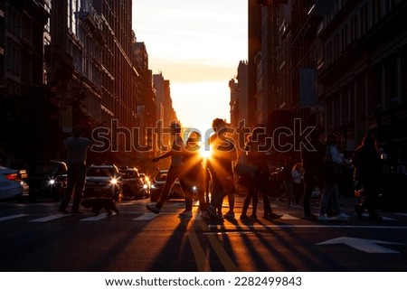 Silhouettes of men and women crossing a busy street in Midtown Manhattan, New York City with sunlight shining in the background Royalty-Free Stock Photo #2282499843