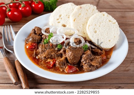 Traditional czech goulash with dumplings on wooden table Royalty-Free Stock Photo #2282529855