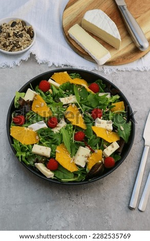 top view of a fresh green salad with oranges and brie cheese 