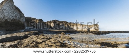 Wild white chalk cliffs at the seashore of England. Beach concept. Flamborough Head. Panoramic outdoor shot. High quality photo