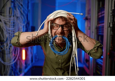 Funny crazy system administrator with head wrapped in wires fooling around