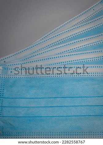 Vertical picture of blue surgical masks stacked in layers, Bacteria protection concept.