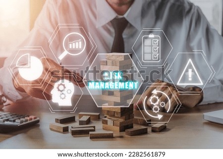 Risk management strategy plan finance investment internet business technology concept, Person hand piling up and stacking a wooden block with icons risk management on virtual screen. Royalty-Free Stock Photo #2282561879
