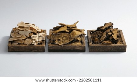 Three wooden trays contained Bai Zhu, Rhubarb root and rhizome and Szechuan Lovage Rhizome. Herbs for health enhancing, very useful in traditional medicine Royalty-Free Stock Photo #2282581111
