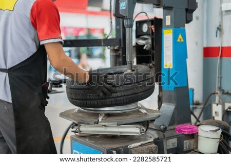 Mechanic changing tires on tire changer in auto service center